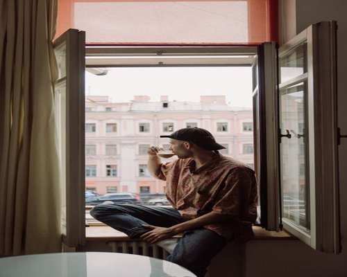 A person enjoying a calm morning with tea by the window in a Polish apartment